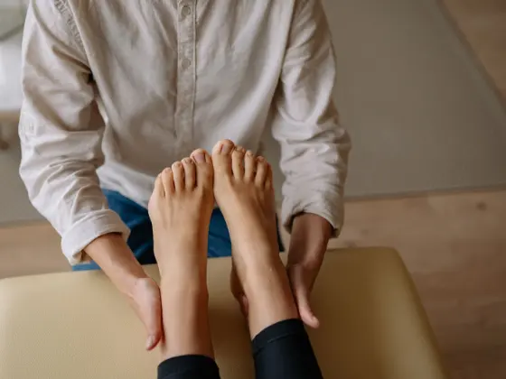 Técnica de terapia manual aplicada no pé e no tornozelo de uma paciente.